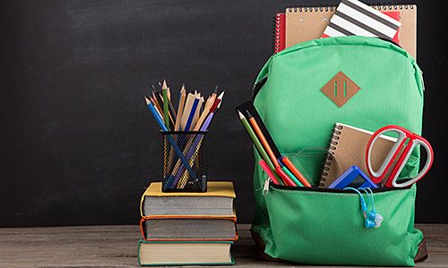 Education concept - school backpack with books and other supplies